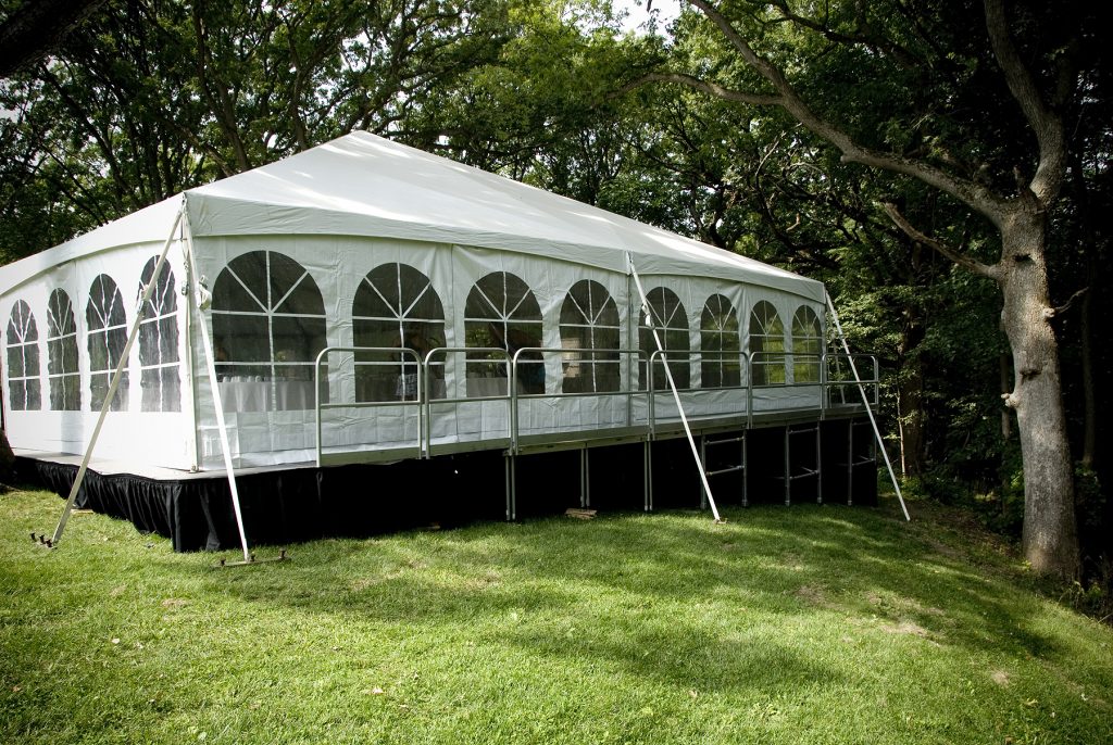 Wedding tent set up on a hill on top of level stage