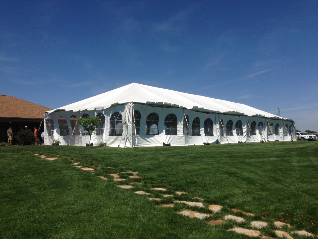 30' x 90' frame wedding tent by pond on a windy day