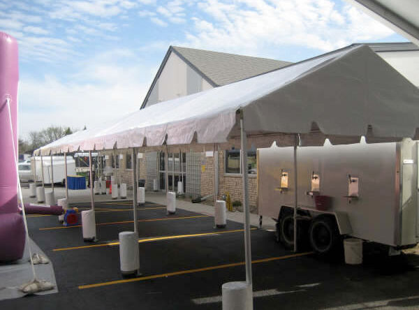 Picture of our long 10' by 50' "frame" tent installed at an event as a concessions stand. Note the beer trailer with taps.