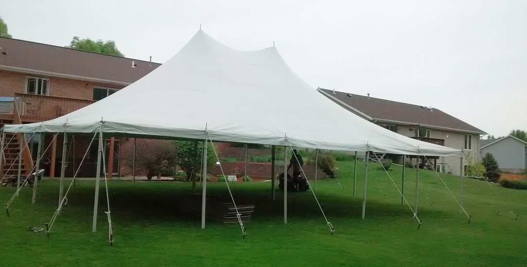 Side view 30' x 40' Rope and Pole tent setup for a backyard high school graduation party.