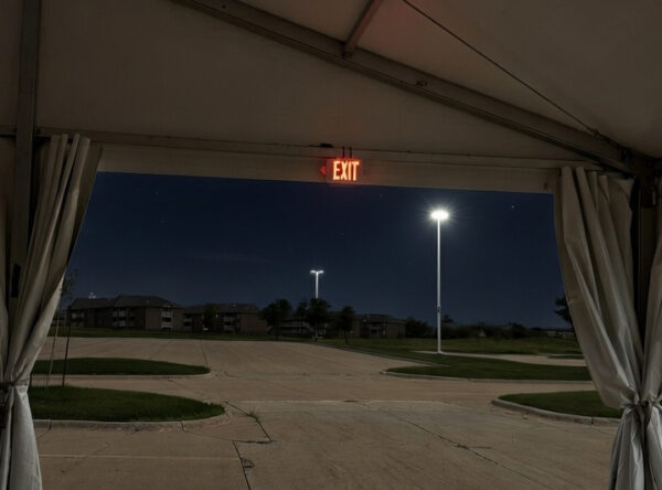 Illuminated exit sign rental in a clearspan tent (AI)