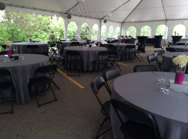 tables and chairs under 30' x 90' frame tent with linens
