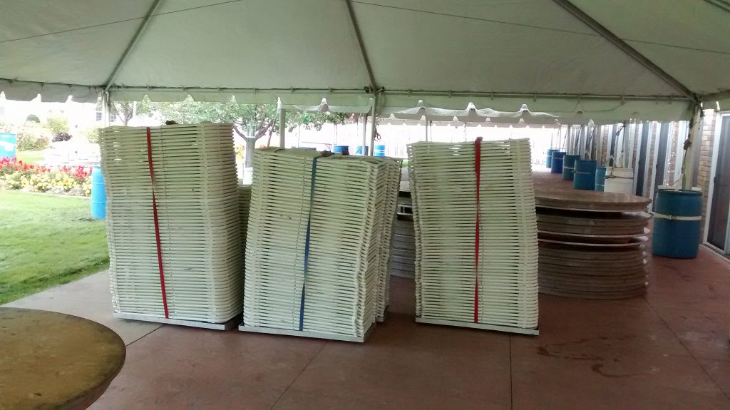 Folding white chairs for event under frame tent