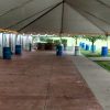 View under 30' x 60' frame tent with water barrels