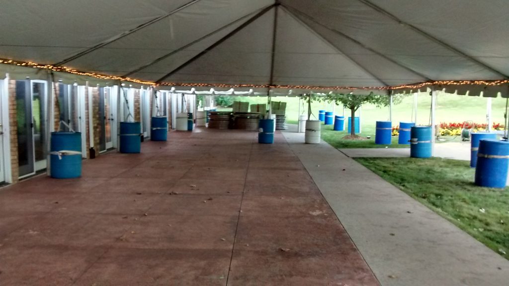 View under 30' x 60' frame tent with water barrels