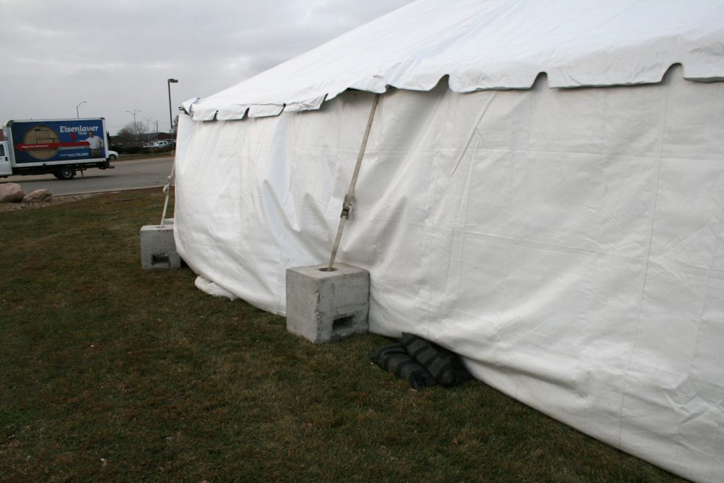 Frame tent with "Block and Roll" ballast and sand bags to hold down the sidewalls in the wind.