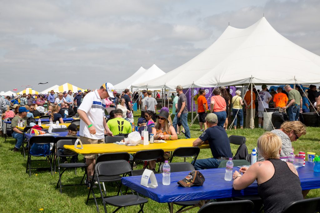 Crowd seated at table and under tent at Quad City Airshow QCAS 2015