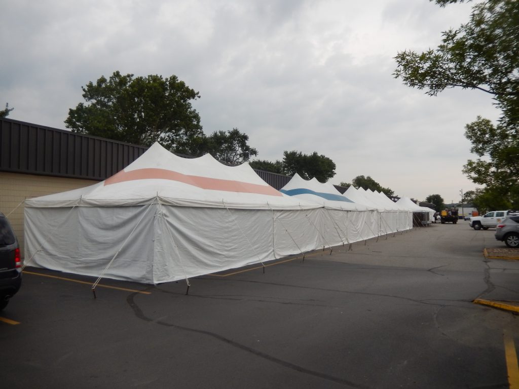 Long line of rope and pole tents set-up for Paul's Sidewalk Clearance sale