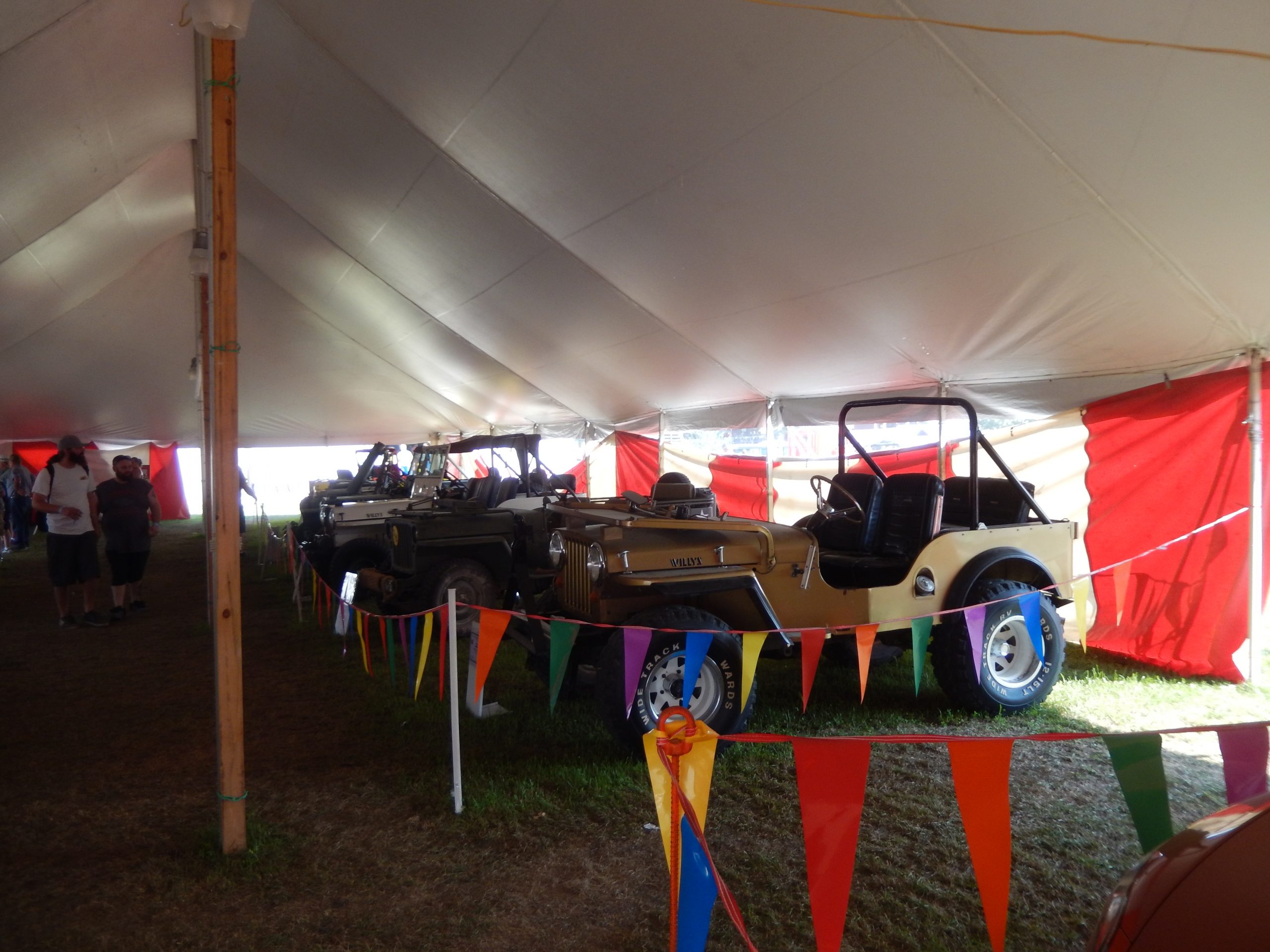 Classic Jeeps under large rope and pole tent