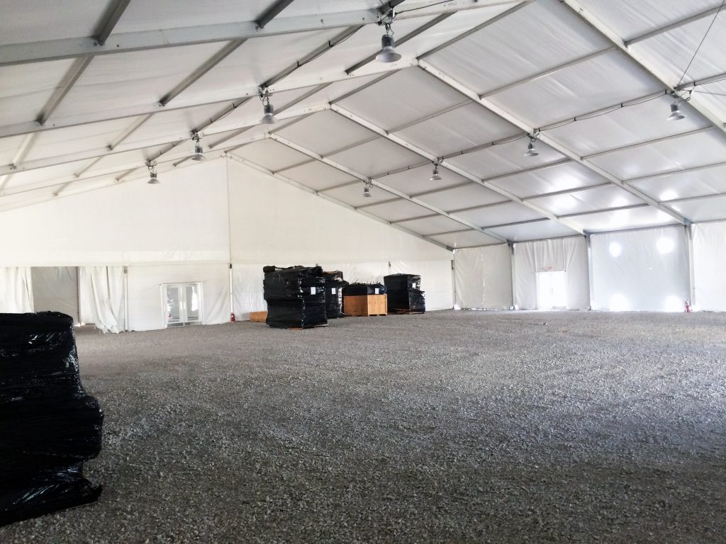 Under 100' x 131' clear span tent with two rows of high-bay lighting