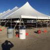 Outside 40' x 120' rope and pole tent with tables and chairs under it