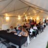 Pictures from under 20' x 50' frame tent with tables, lights, linens and chairs at event