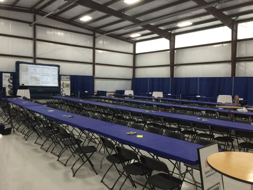 Tables and black chairs setup for Iowa City Area Development Group event