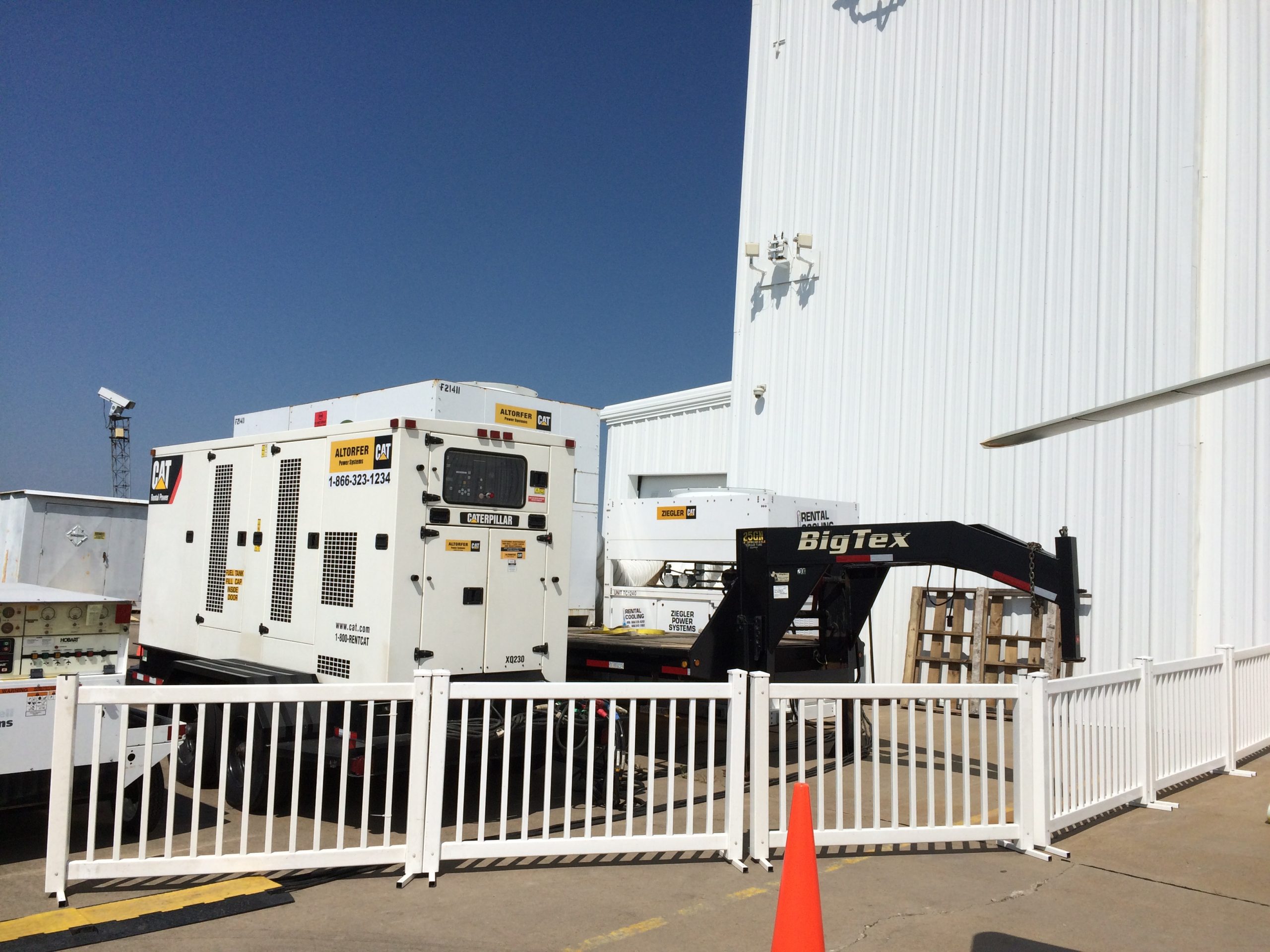 Temporary fencing around Generator and Air Conditioning units outside of airplane hangar