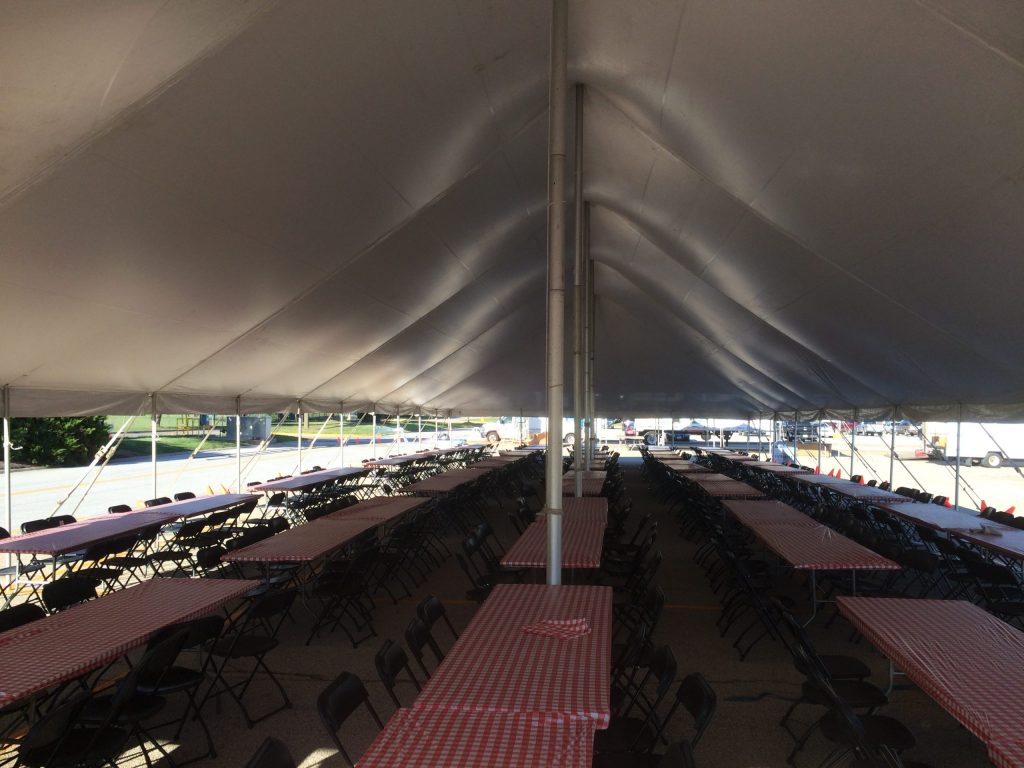 Under 40' x 120' rope and pole tent with tables and chairs