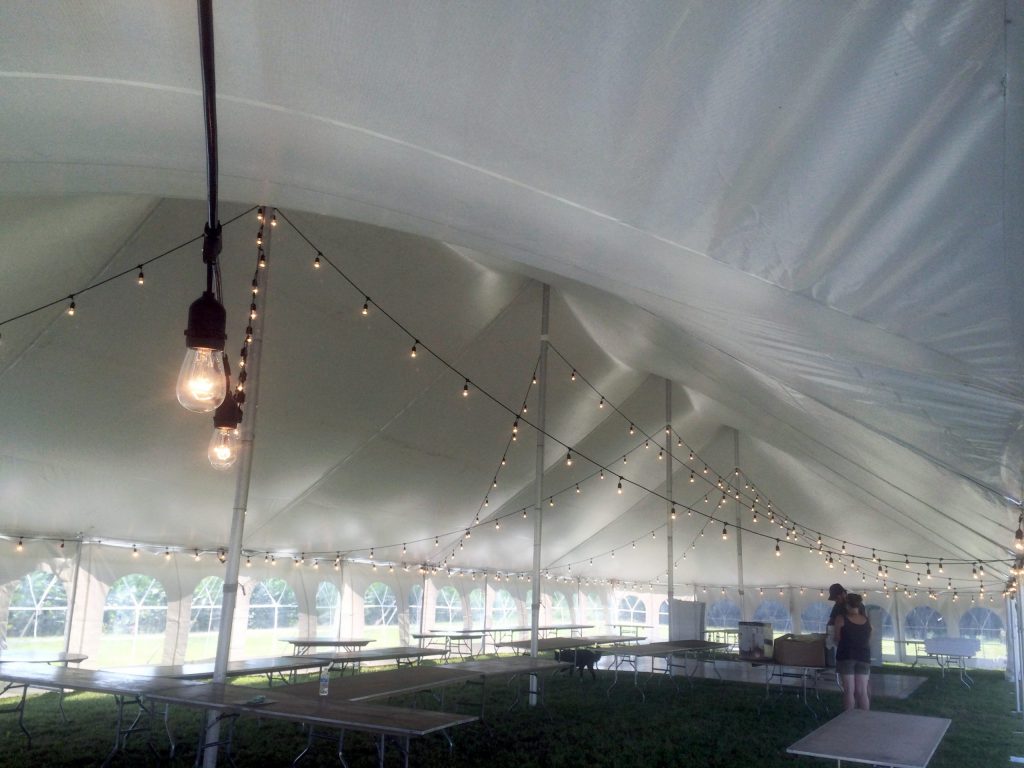Under of 40' x 100' rope and pole wedding tent with sidewall and Edison lights
