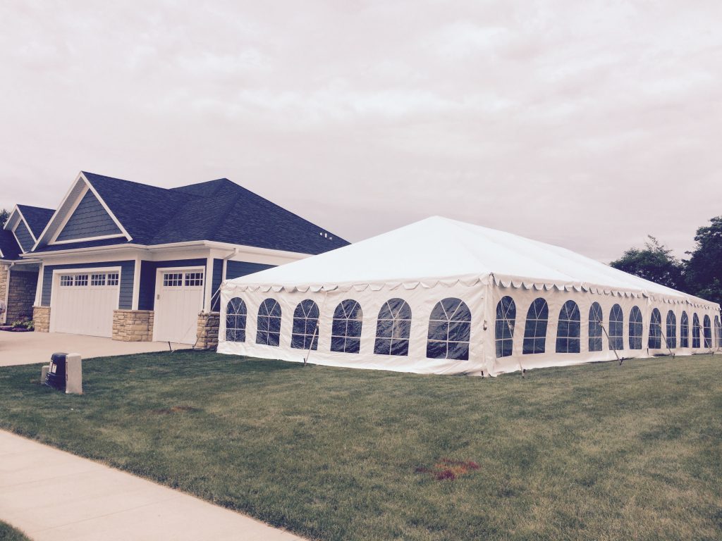 Home with 30' x 60' frame tent in side yard for wedding reception in Dubuque, Iowa