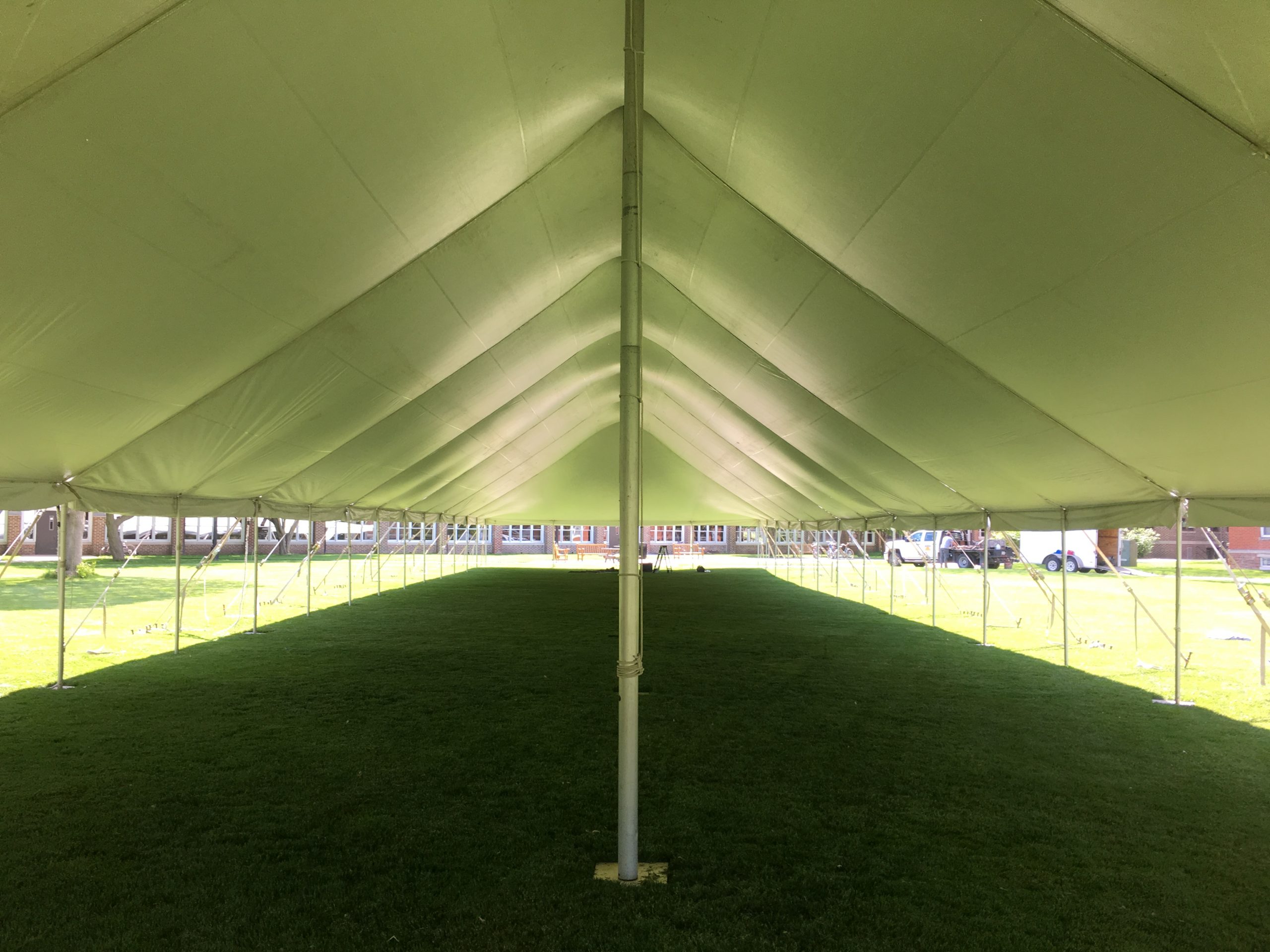 Under the middle of a 40' x 160' rope and pole tent for Commencement at Grinnell College 2016