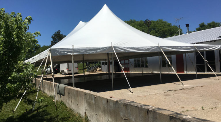 40'x60' Rope and Pole Tent with concrete wall obstruction for an outdoor wedding reception