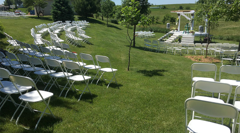 Outdoor wedding with chairs and tents at HighPoint City Church in Iowa City, IA