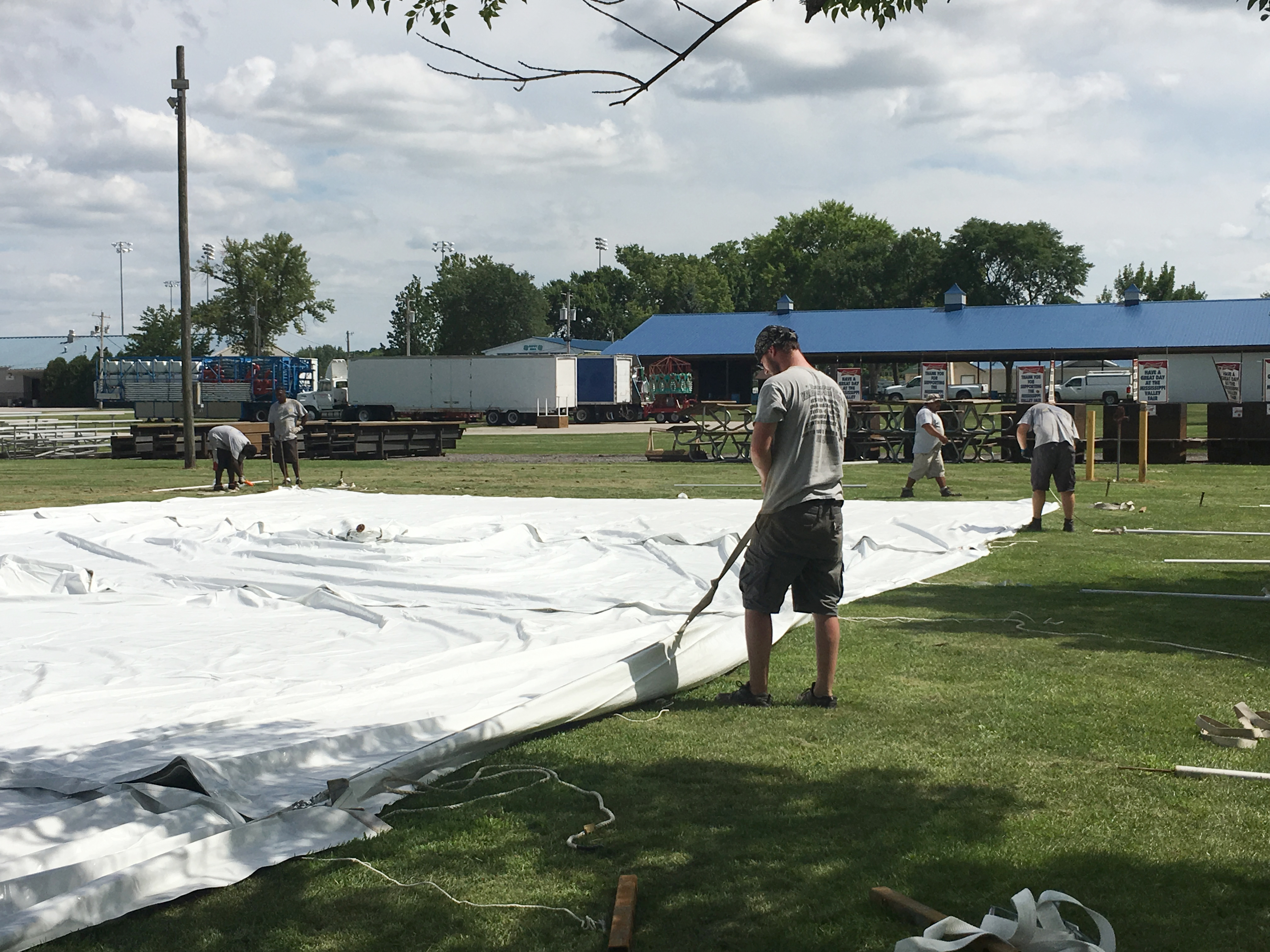 Attaching straps to rope and pole tent on the ground at the Mississippi Valley Fair 2016