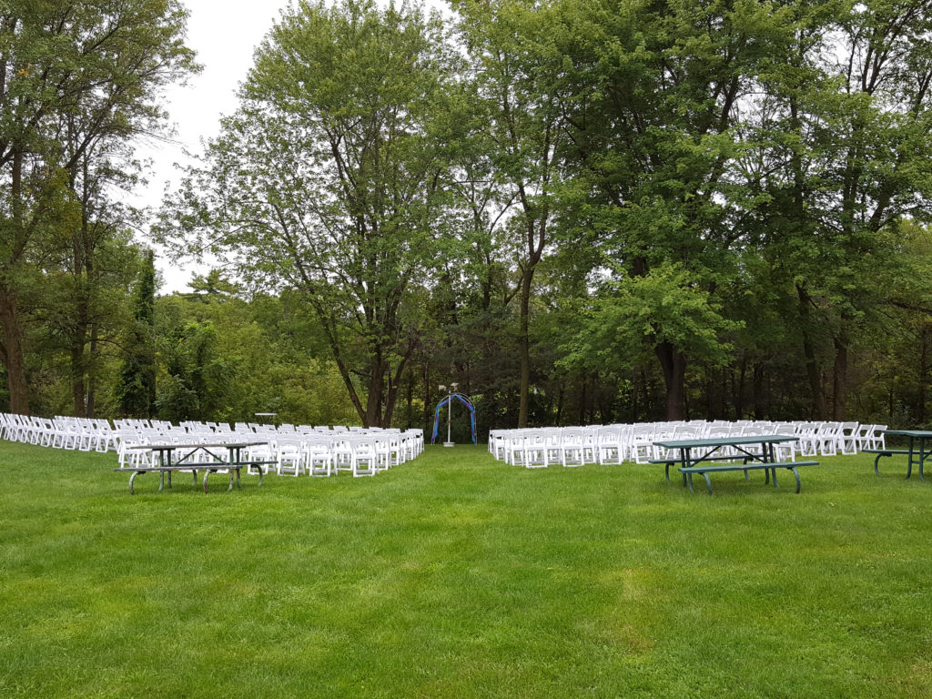 Back view of 200 White Padded Resin Chairs for an outdoor wedding in Wapsipinicon Park in Anamosa, IA