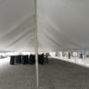 Under the middle of the 40' x 120' rope and pole tent at Knoxville Raceway (Marion County Fairgrounds) in Iowa with black chairs