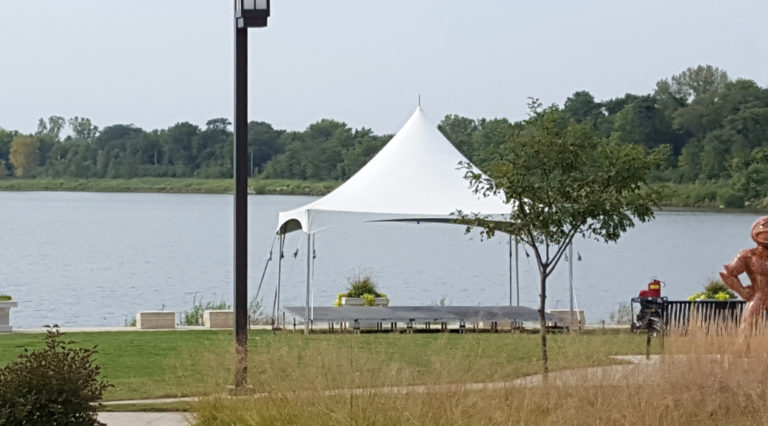 20' x 20' Tentnology tent with stage underneath it at Terry Trueblood Recreation Area for Jingle Cross Cyclecross event