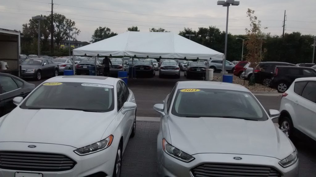 20' x 30' frame tent for the grand re-opening at Coralville Used Car Superstore view by cars