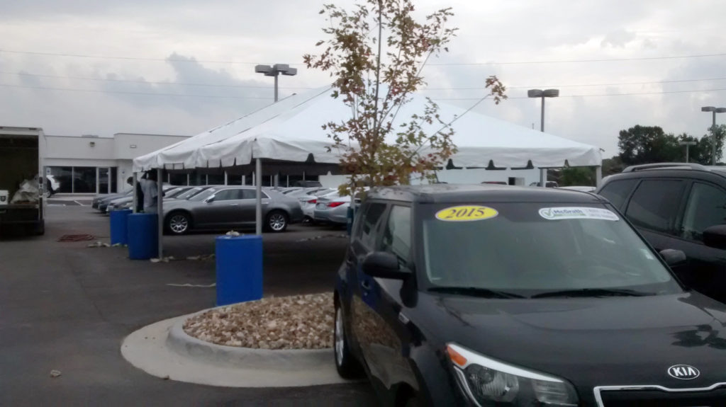 20' x 30' frame tent for the grand re-opening at Coralville Used Car Superstore with water barrels