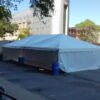 20' x 40' frame tent with water barrel and sidewalls between Rienow Hall and Quadrangle Hall in Iowa City