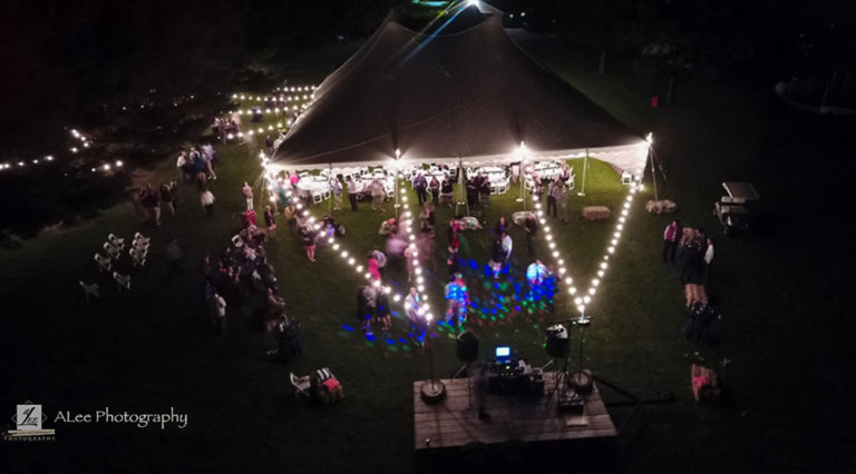 Outdoor wedding reception under a 60′ x 90′ rope and pole tent in Protivin, Iowa