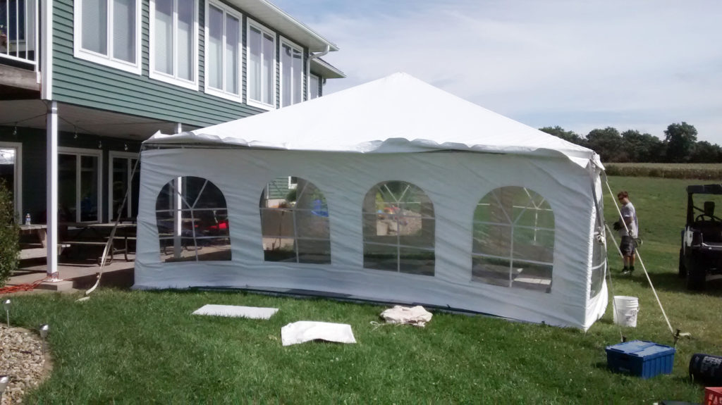Outside of 20' x 20' frame tent with black and white checked dance flooring for 50s style anniversary party