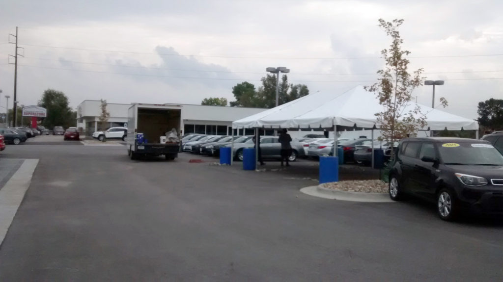 Setting up 20' x 30' frame tent for the grand re-opening at Coralville Used Car Superstore