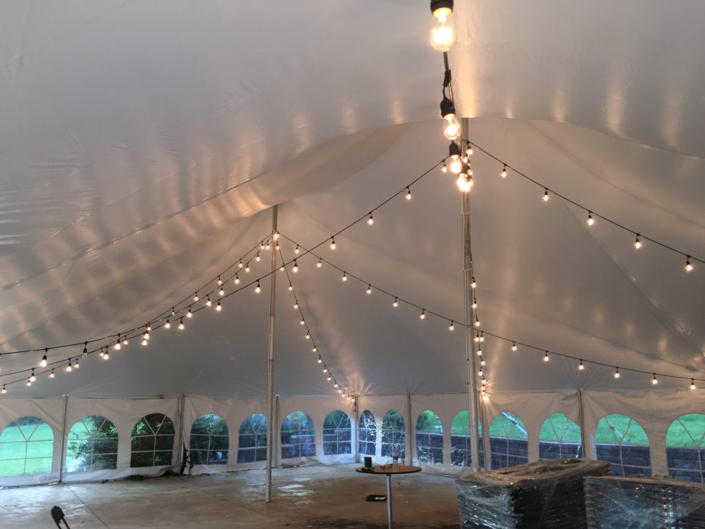 Under 40' x 60' white rope and pole wedding tent at Harvest Preserve with Edison cafe string lights
