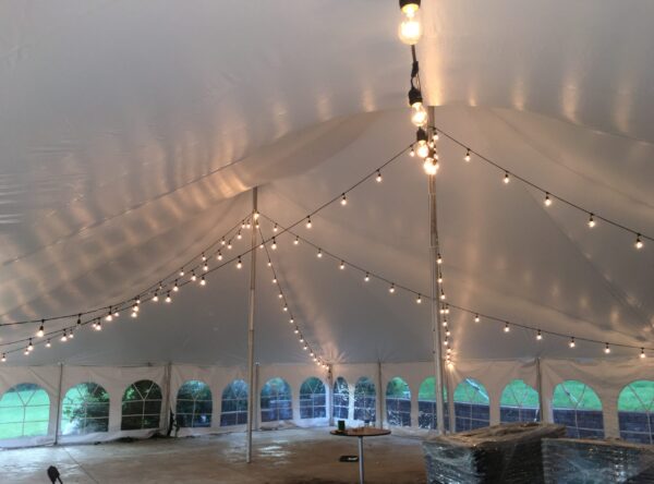 Under 40' x 60' white rope and pole wedding tent at Harvest Preserve with Edison cafe string lights