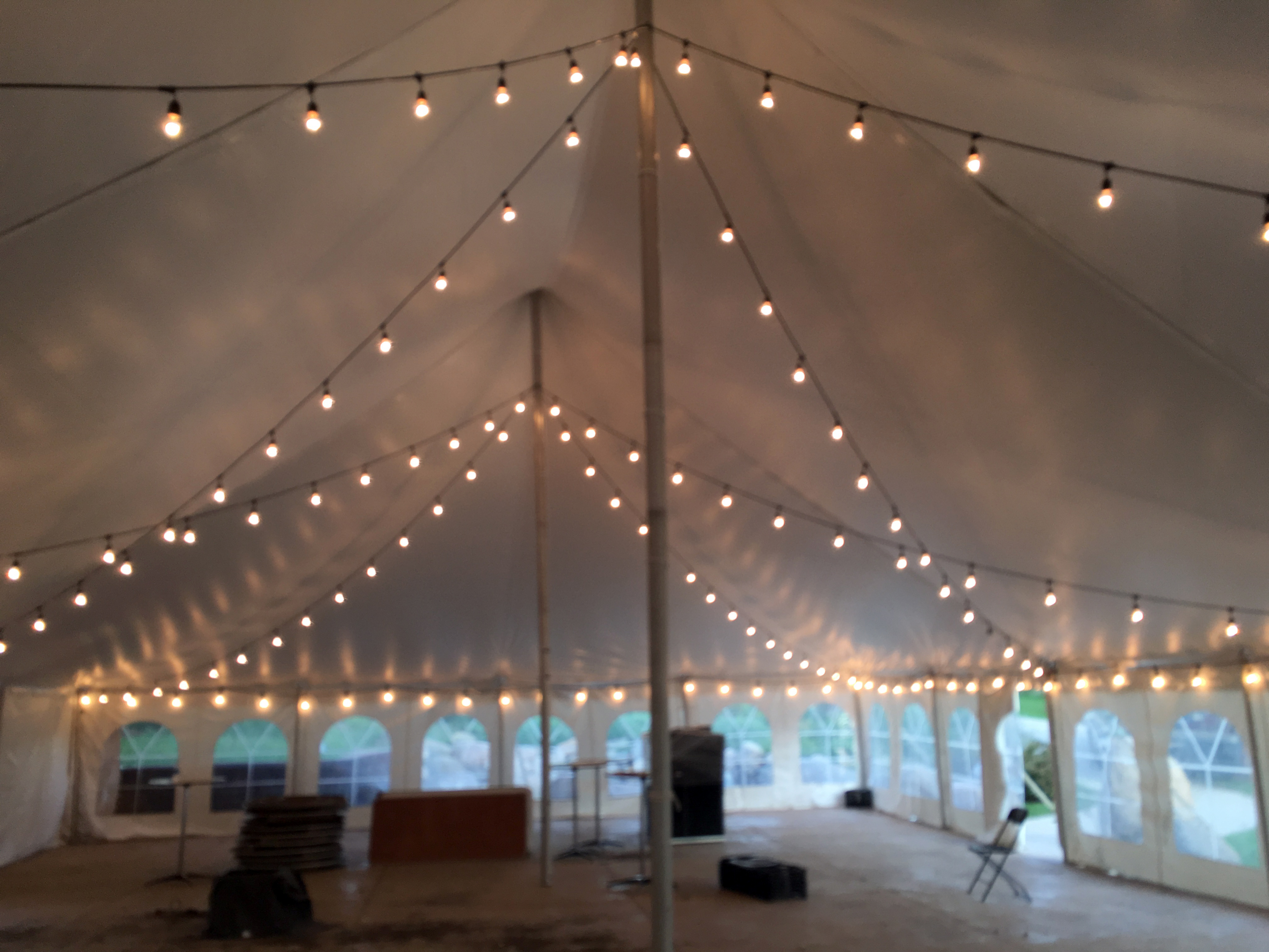 Under 40' x 60' white rope and pole wedding tent at Harvest Preserve with lights