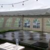 View under 20' x 20' frame tent with black and white checked dance flooring for 50s style anniversary party