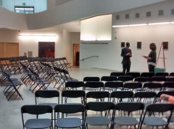 Black chairs set up in rows for a conference