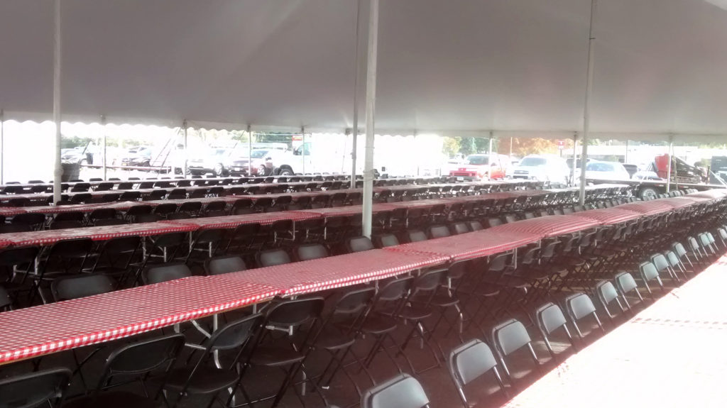 Under our 60' x 90' rope and pole tent with tables for seating setup for Morris & Company Entertainment in Davenport, Iowa