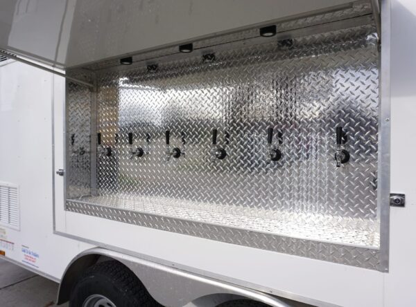 Closeup view of the six taps on the refrigerated draft beer trailer for rent