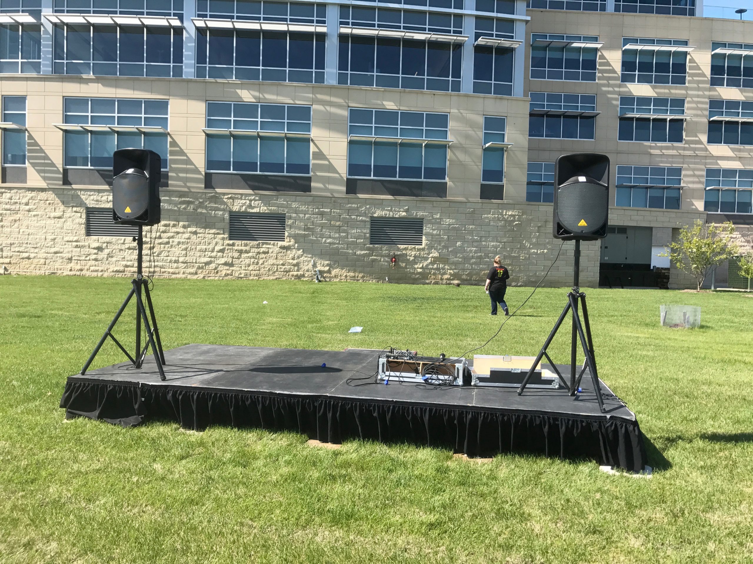 8' x 16' stage with PA Pro Package and tripod stands behind UICCU Financial Center Building in Iowa
