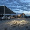 18m x 20m (60′ x 66)’ Clearspan Tent on the left and a 40′ x 60′ Clearspan Tent on the right at dusk