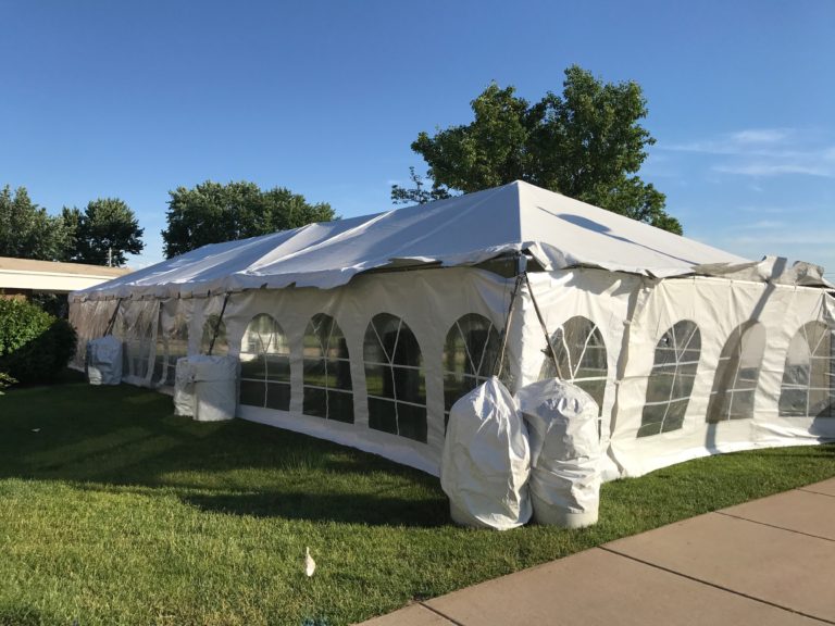 20' x 60' frame tent with French Sidewalls and Water Barrels for a wedding reception at a St John Vianney Church in Bettendorf Iowa