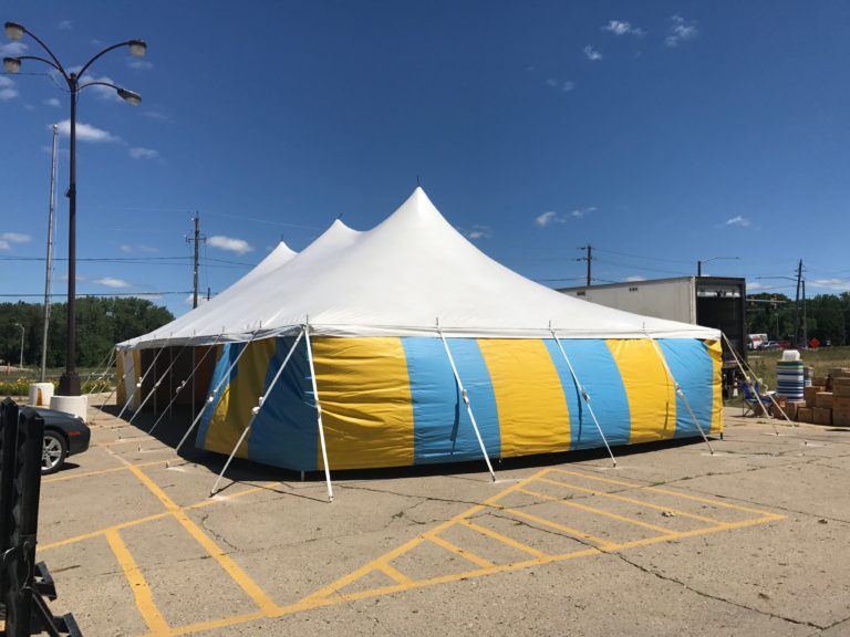 End of White top 30' x 60' rope and pole (one piece) tent for Kaboomers fireworks Des Moines, Iowa with blue and yellow side walls