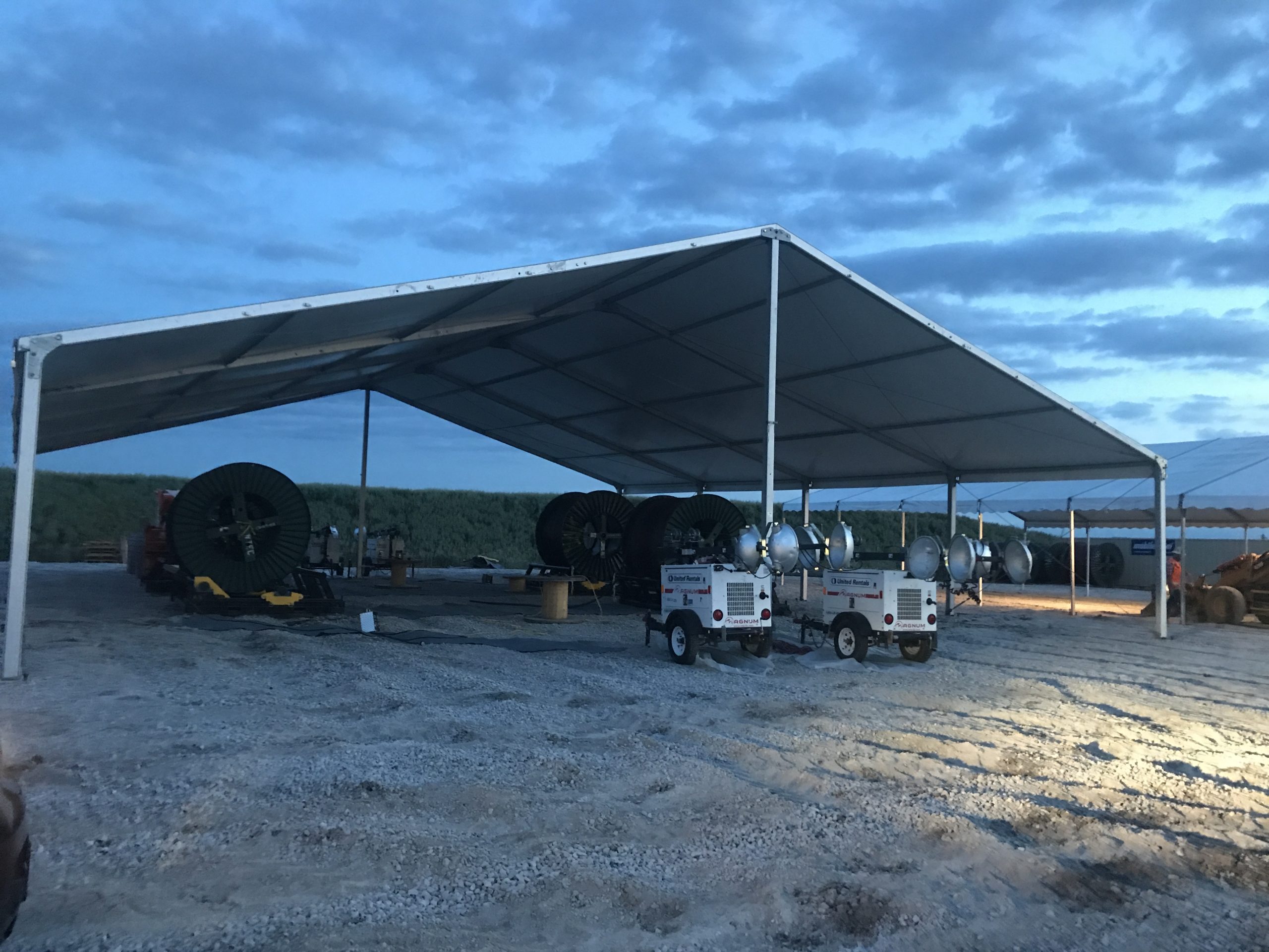 Last minute construction site setup 18m x 20m (60′ x 66)’ Clearspan Tent at dusk