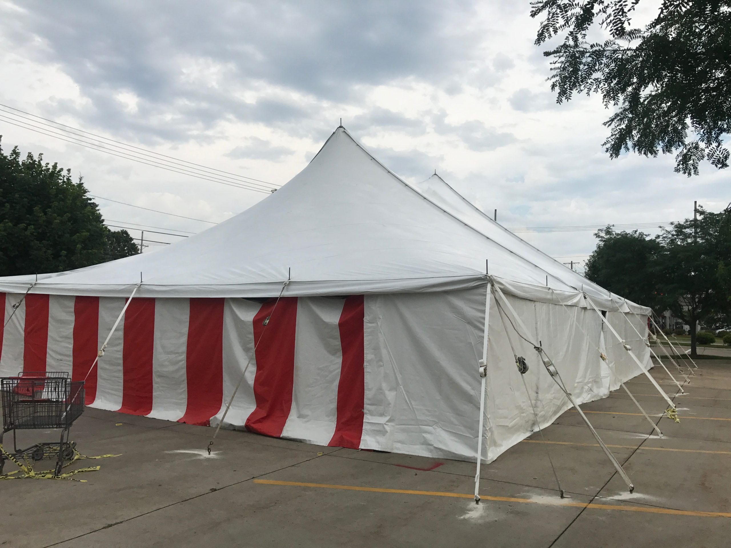 Outside of a 40' x 60' rope and pole tent with Red and White Sidewall used for Fireworks tent at Hy-Vee in Cedar Rapids, Iowa