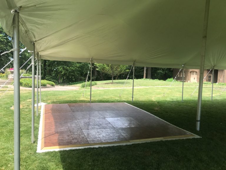 Under the 20' x 40' rope and pole tent with dancefloor for a wedding reception at a St John Vianney Church in Bettendorf IA