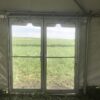Under the 20' x 60' frame tent looking out the glass door into the field