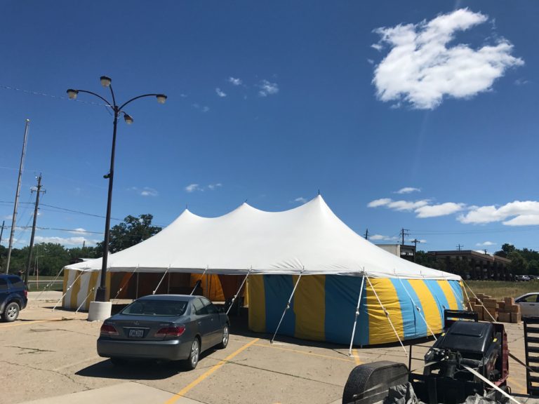 White top 30' x 60' rope and pole (one piece) tent for Kaboomers fireworks Des Moines, IA with blue and yellow side walls